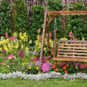 Wooden swing seat in flower garden